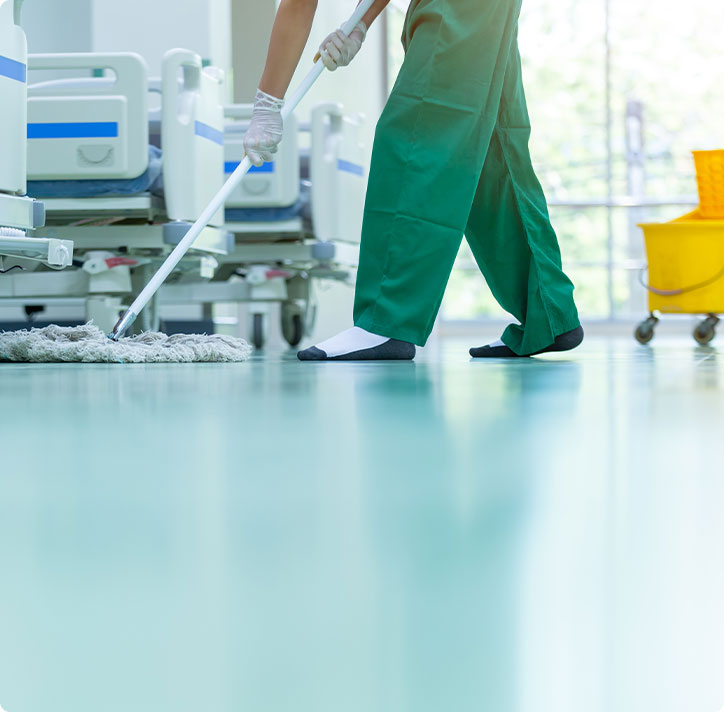 Cropped image of commercial cleaner in green pants providing medical office cleaning in Denver.
