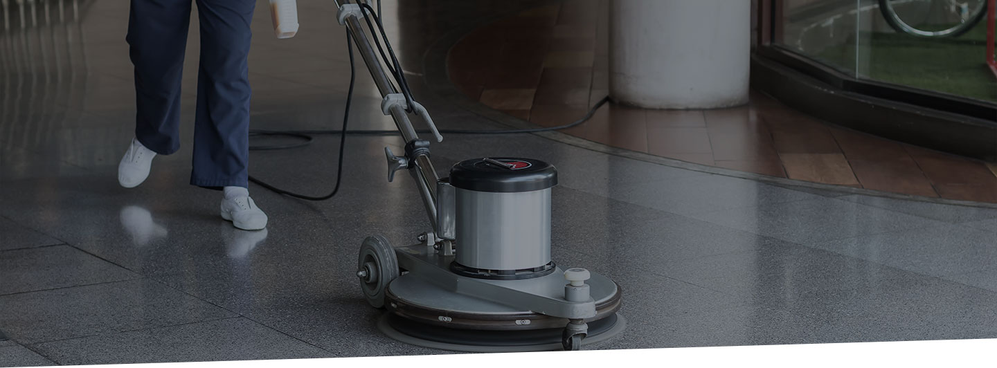Cropped image of a professional using an industrial floor cleaner on tile floors.
