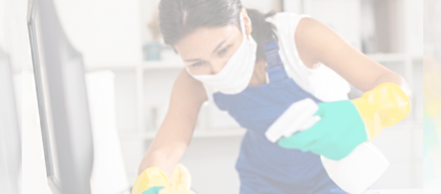 Close up of female cleaner in mask disinfecting high-touch surface area.