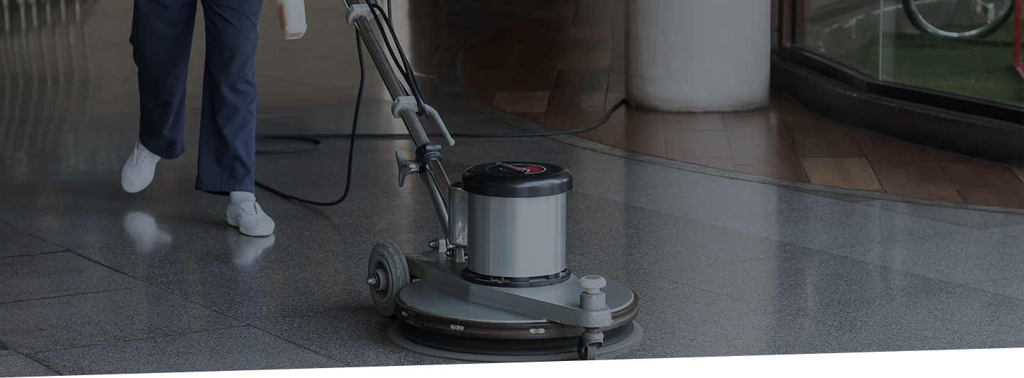 Cropped image of a professional using an industrial floor cleaner on tile floors.
