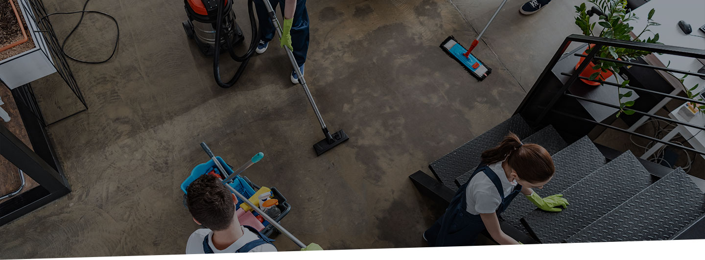 Team of commercial professionals cleaning an office area.