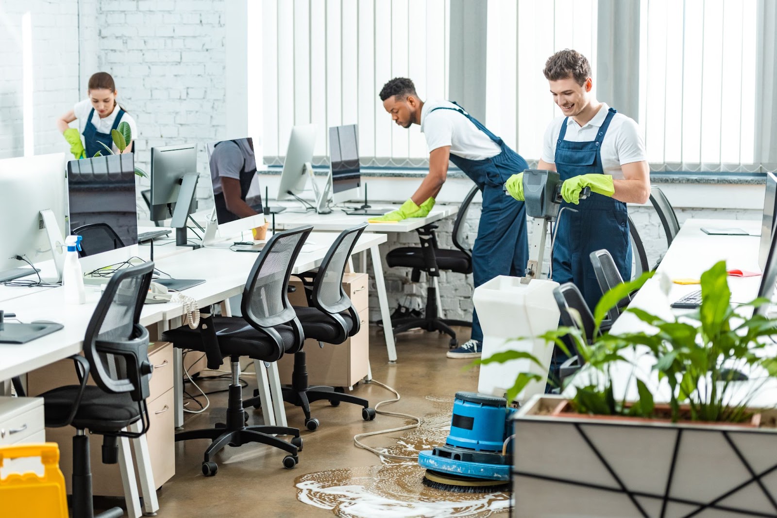 A team of professional cleaners power-washing office floors.